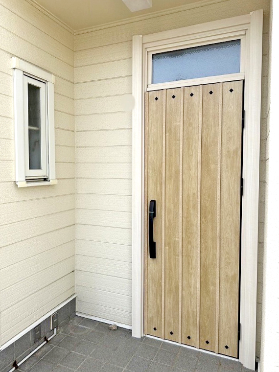 ガラスのランマがついた木目調の片開きドアにリフォーム