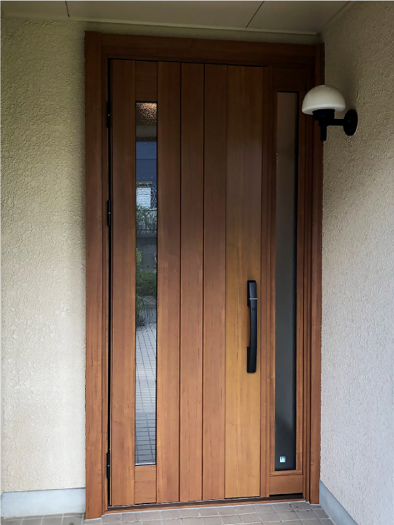 施工後のスリットと袖から光が取り込める木目調の新しい玄関ドア