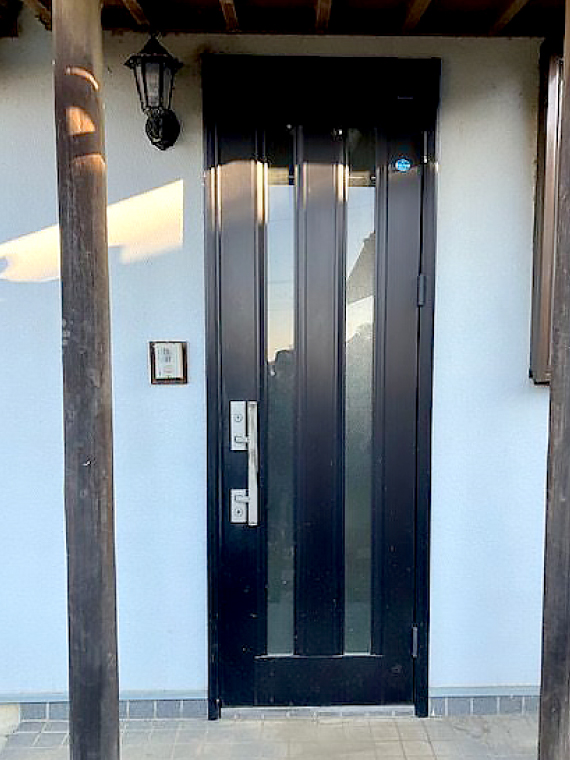 目の前に大きな柱が2本立っているアルミ調の片開きドア