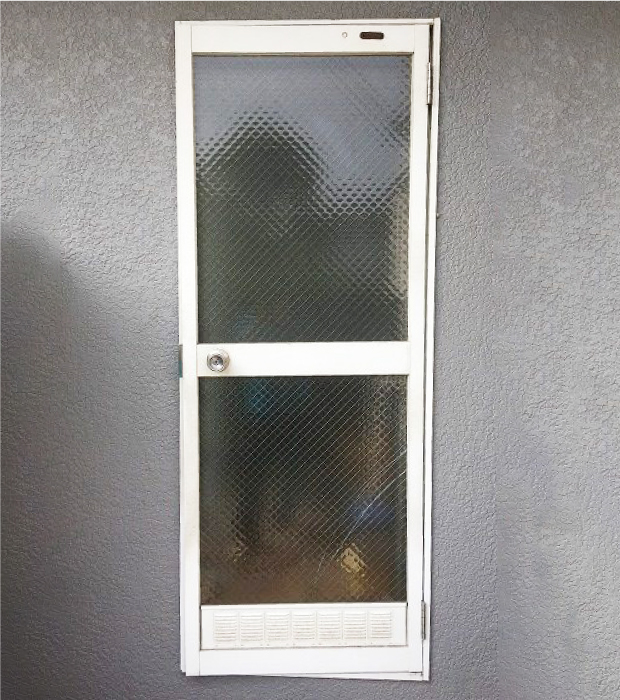 施工前の勝手口ドアは古びた印象で、ガラス面も大きく防犯面に不安を感じます