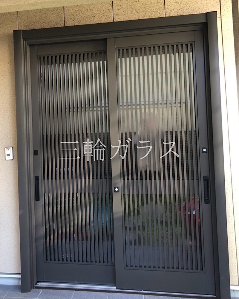 リフォーム後の名古屋市の玄関引戸。LIXIL「リシェント玄関引戸2」P11型（オータムブラウン）。ランマを無くした高い障子デザインでスタイリッシュな外観。