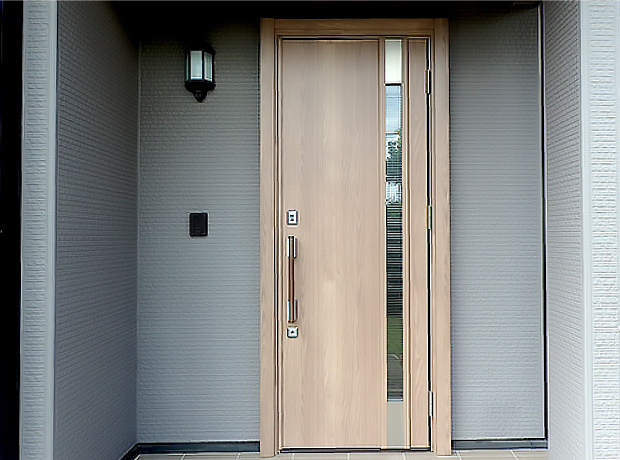 施工後のシナモンエルム色をした木目デザインの片開きドア。断熱仕様とエントリーキーの採用で見た目も機能も安心安全です