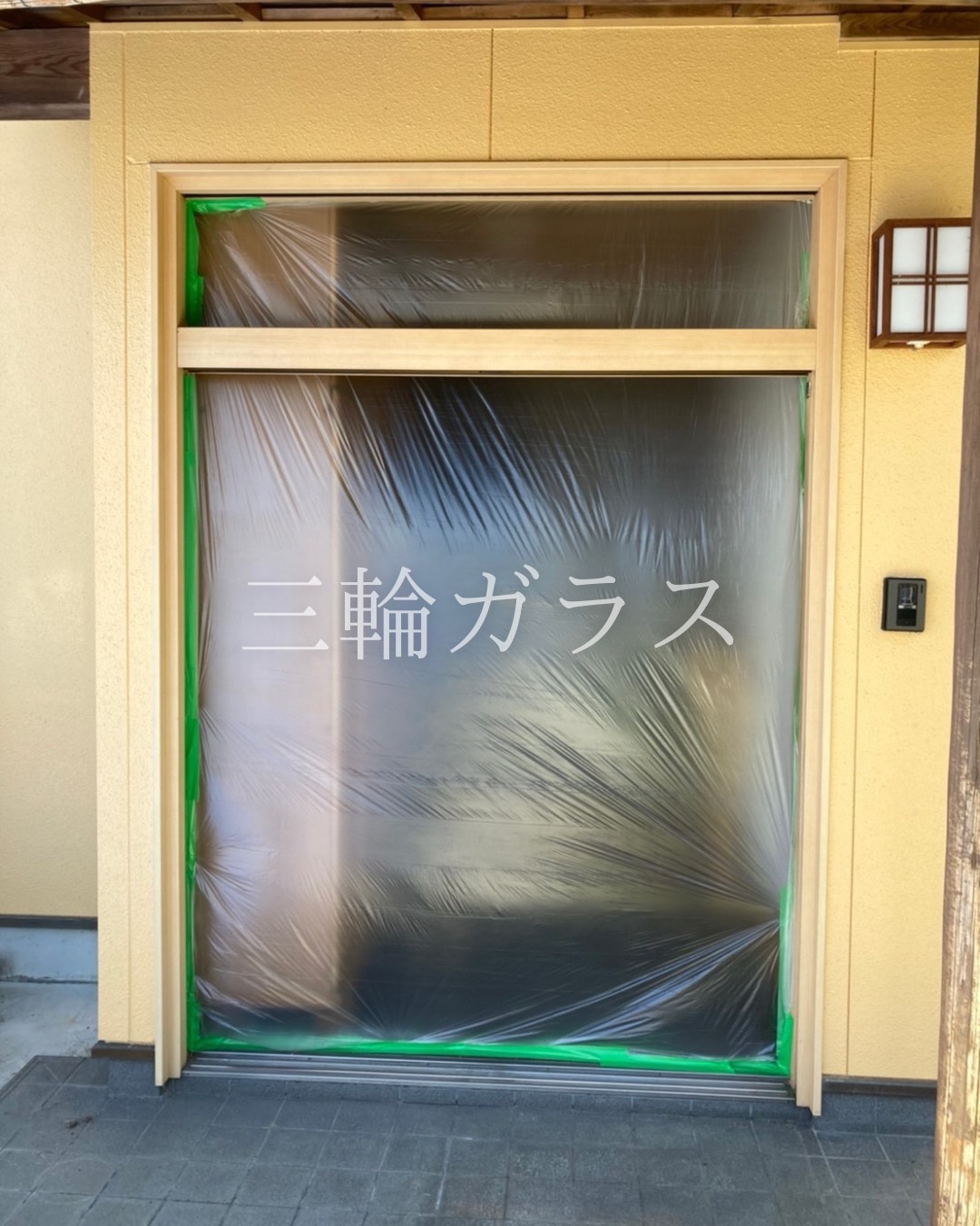 玄関引戸のカバー工法による施工中の様子。LIXILリシェントの新しい枠を取り付け、養生を施した状態。