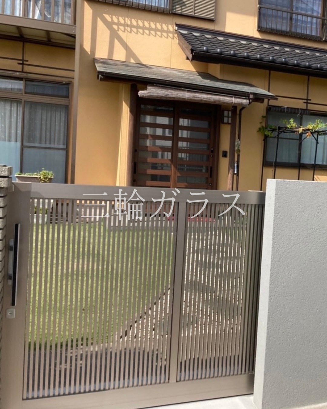 大府市のお住まいに新設された、LIXIL製スライド（引戸）門扉（シャイングレー色）が閉まった様子。縦格子のデザイン。