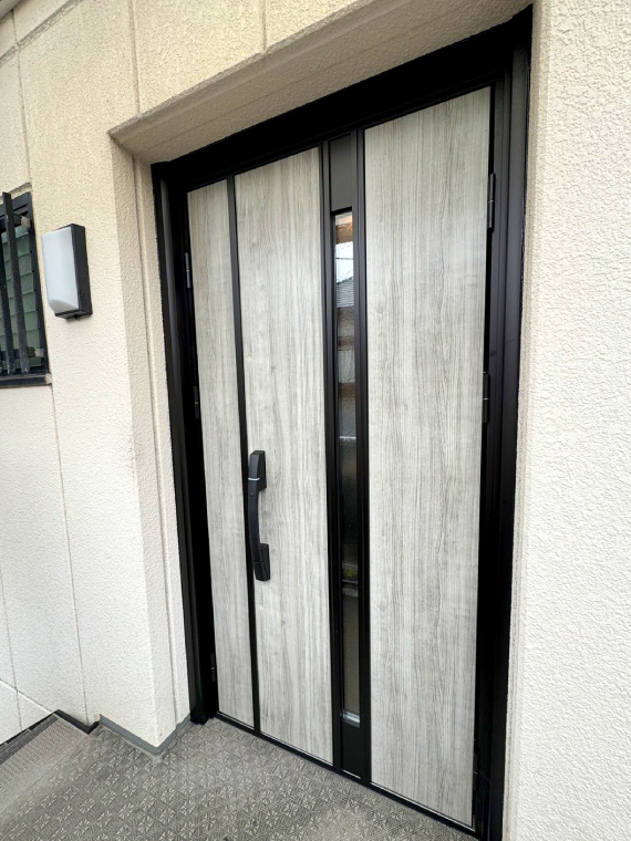 リフォームで壊れた鍵もスマートキーに一新！木目調扉と黒い枠がアクセントのモダンな雰囲気の玄関ドアになりました