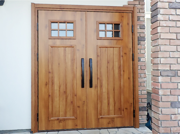 施工後の新しい暖かみのある木目調の両開き玄関ドア