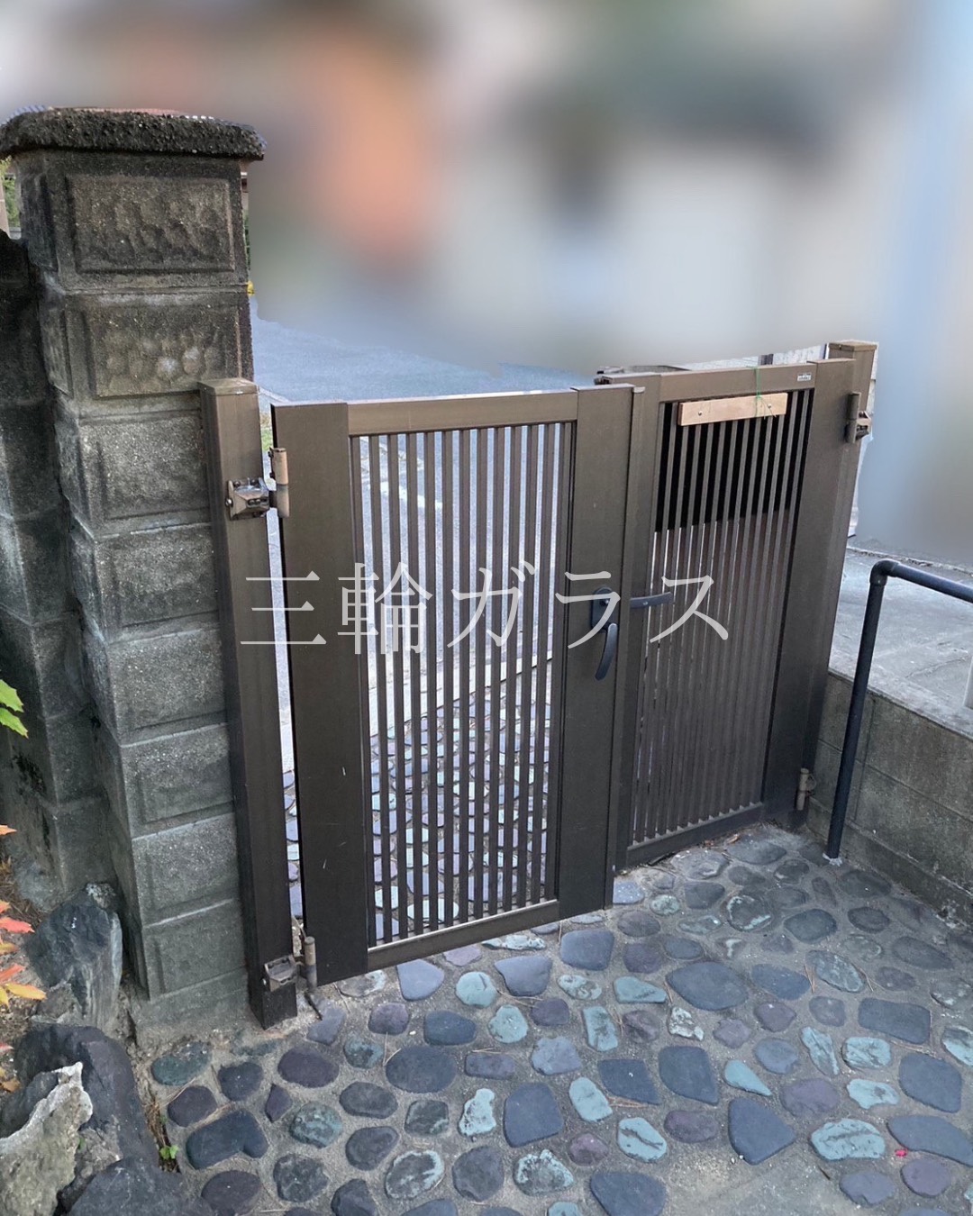 経年劣化により傷みが目立ち、小扉のフランス落としが故障した古いアルミ製門扉の施工前写真。