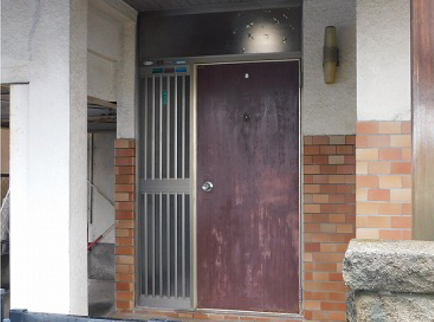 木製ドアの表面塗装が剥がれ、全体的に古い印象を与える施工前のドア